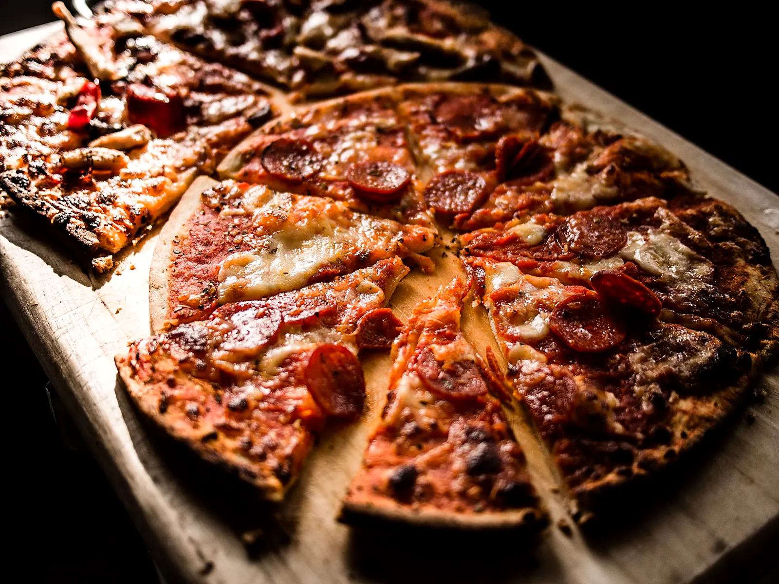 Rustic pizzas on a dark wooden board