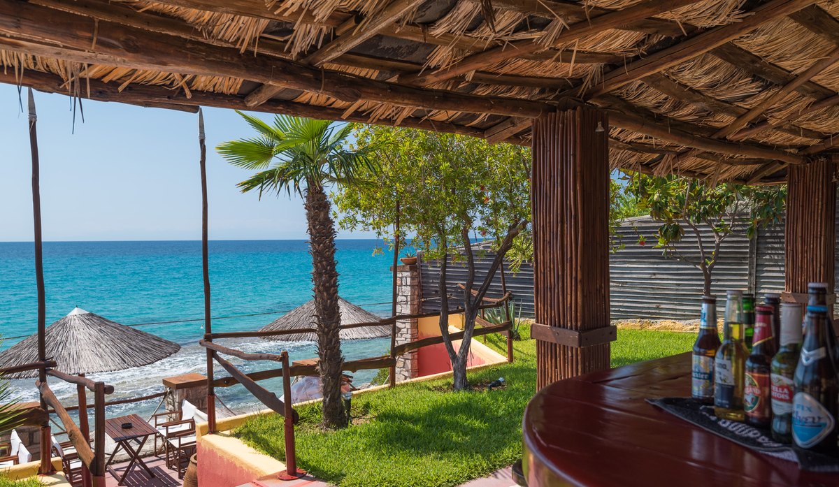 Bar counter with cold drinks and the sea beyond at Kudu Beach Bar